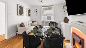 Ein modernes Wohnzimmer mit einem Glastisch, einem weißen Sofa und einem Kamin.