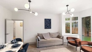 Ein modernes Wohnzimmer mit Essbereich, einer Couch und einem großen Fenster.