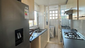 Eine moderne Küche mit einem Edelstahl-Kühlschrank, einem Gasherd und einem Wasserspender.