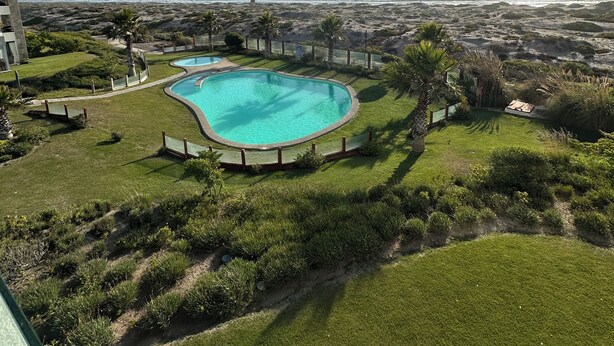 Ein Pool mit Blick auf das Meer und ferne Berge.