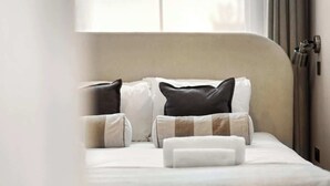 Ein ordentlich bezogenes Bett mit Kopfteil, Kissen und Decke.