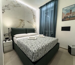 A modern bedroom with a marble headboard, a bed with patterned bedding, a nightstand, a lamp, a window with curtains, and a wall-mounted artwork.