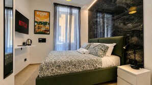 A modern bedroom with a green bed, a flat-screen TV, a poster of Rome, Italy, and a marble wall.