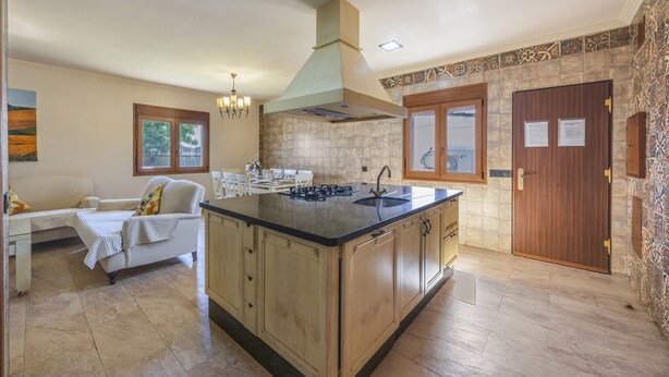 A spacious kitchen with a large island, wooden cabinets, and a built-in oven.