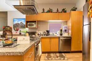 A modern kitchen with wooden cabinets, stainless steel appliances, and a sign that reads 'YOUR CASA Mexican Experience'. - Colorful Roma Norte 3BR/3BA, 2 patios, AC (Mexico City)