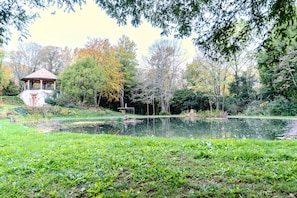 A gazebo, a pond, and surrounding trees.