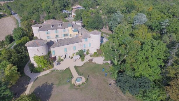 A large estate with multiple buildings, a central courtyard, and surrounding lush greenery. - Tour Est Vacation Rental at Château de Vachères. (Montclar-sur-Gervanne)