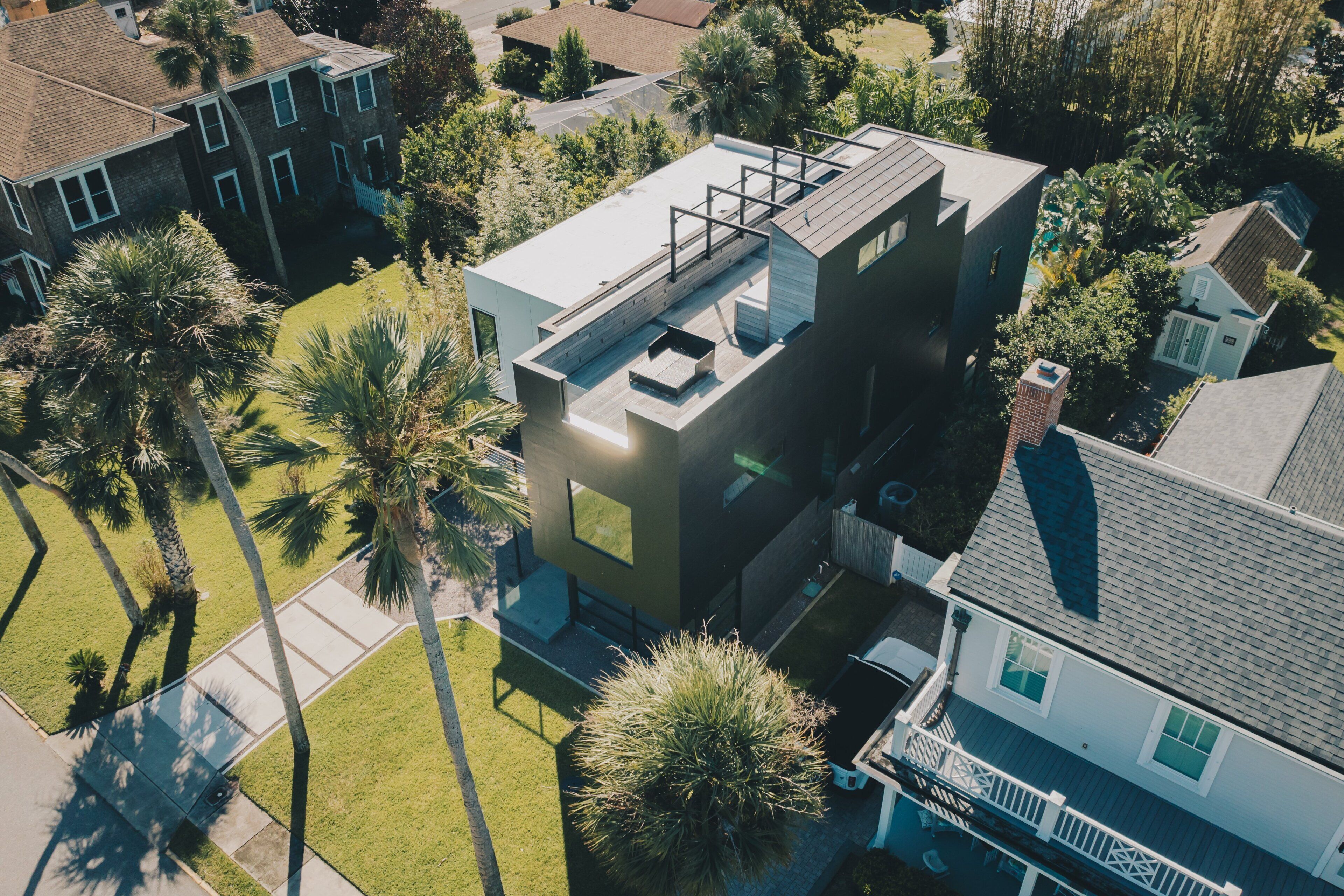 A modern house with a flat roof, large windows, and a small balcony.