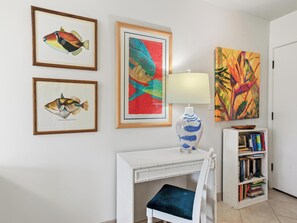 A room with a white desk, a chair, a lamp, and framed fish illustrations on the wall. - Wailea Ekahi Village 20D (Wailea)