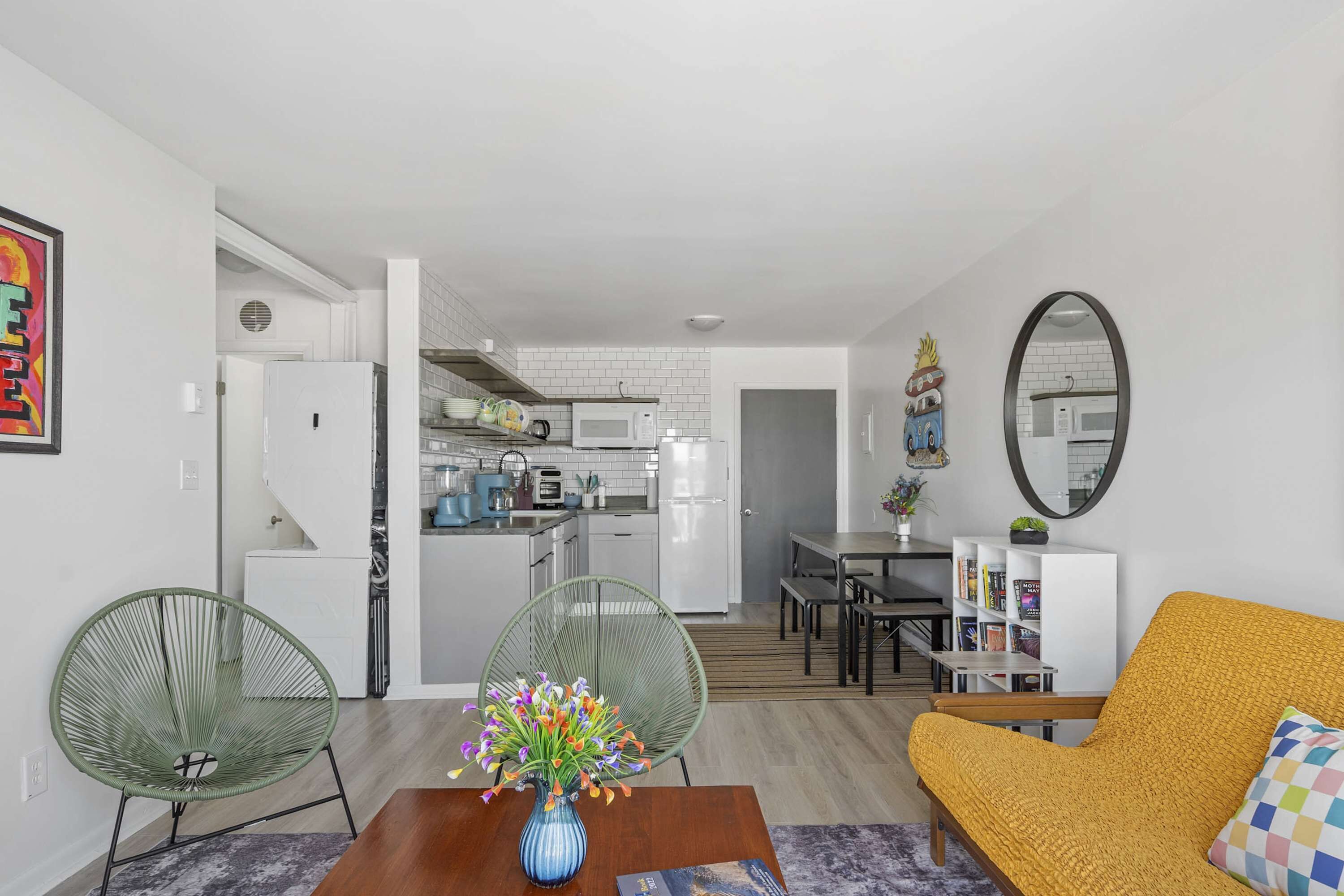 Een moderne woonkamer met een bank, stoelen, een salontafel en een eethoek met een tafel en stoelen.
