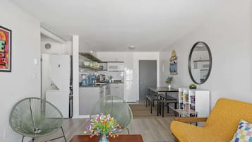 Een moderne woonkamer met een bank, stoelen, een salontafel en een eethoek met een tafel en stoelen.