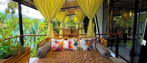 Una habitación amplia con una cama grande, cortinas amarillas y vistas al paisaje exterior.