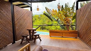Una habitación con una cama, una mesita y un banco.