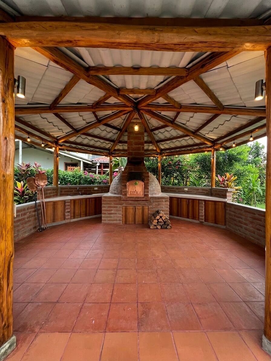 An outdoor patio with a brick fireplace, wooden beams, and a tiled floor.