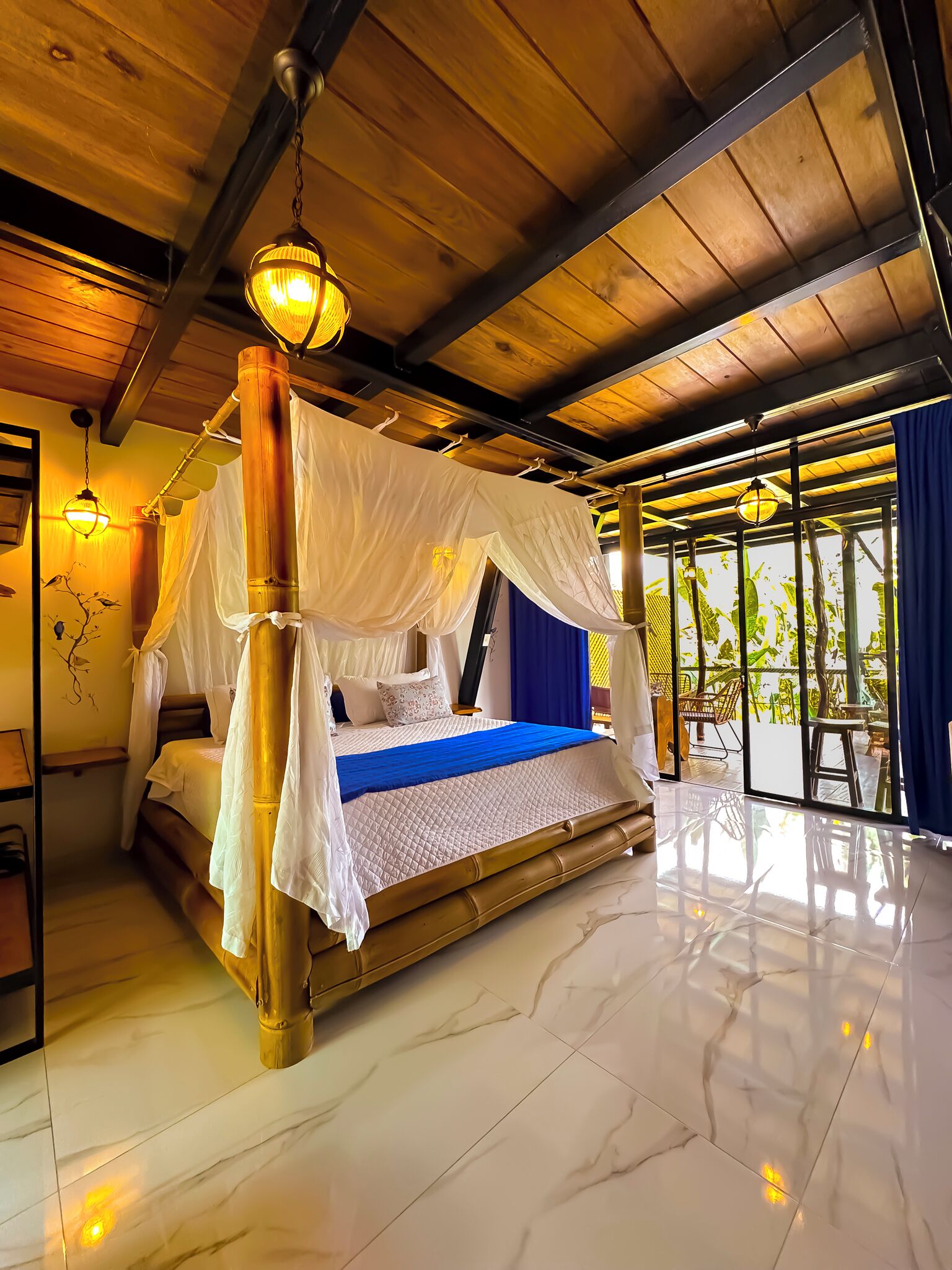 A room with a bed, a ceiling fan, and a view of the outdoors.