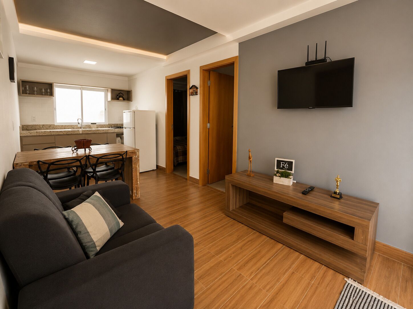 Una sala de estar moderna con un sofá, una mesa de centro y un televisor montado en la pared.