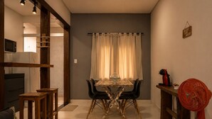 Un espacio habitable compacto con una mesa de comedor, sillas, un sofá y un ventilador.