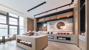 A modern kitchen with a central island, built-in appliances, and a large window offering a view. - Ni Hao Hotel Quanzhou Olypmic  Center (Quanzhou)