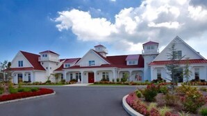 A large, white building with multiple red roofs and a central tower. - New Coastal Club Luxury Villa w Resort style Amenities | Sleeps 8 | 3BR / 2.5 Baths (Lewes)