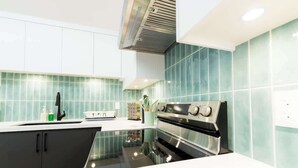 Eine moderne Küche mit Backofen aus Edelstahl, einer Spüle und einer Spritzschutzwand.