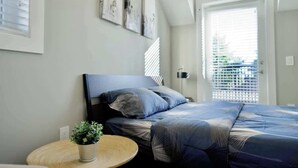 A bedroom with a bed, a round table with a plant, and artwork on the wall. - Private 3Bed Entire House/ 15 mins YVR/ 20 mins DT (Vancouver)