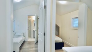 Un dormitorio con cama, ventana y puerta que da a otra habitación.