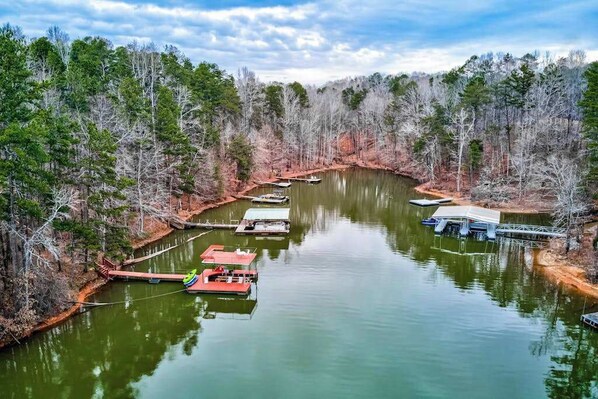 A calm river with boats docked, surrounded by a forested area. - Lakeside Oasis Stays (Gainesville)