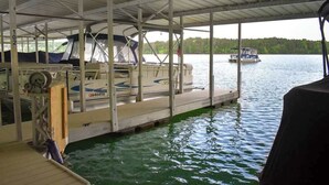 A covered dock with a boat, a motor, and a canopy. - Lake Chatuge Retreat (Hiawassee)