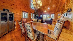 Interno di una baita di legno con angolo ristoro, cucina e soggiorno.