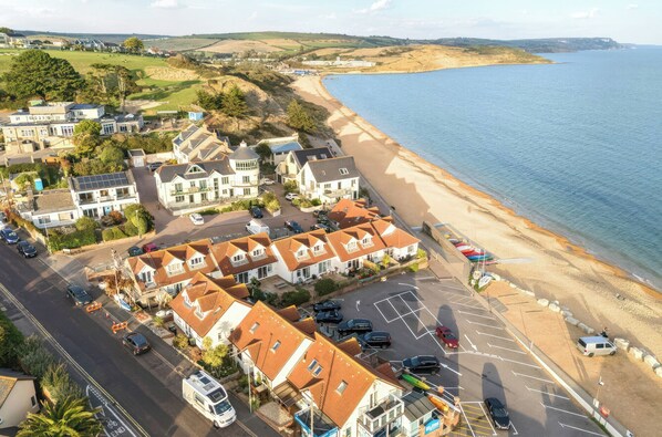 A coastal residential area with houses, a beach, and a road. - Bella Rosa (Weymouth)