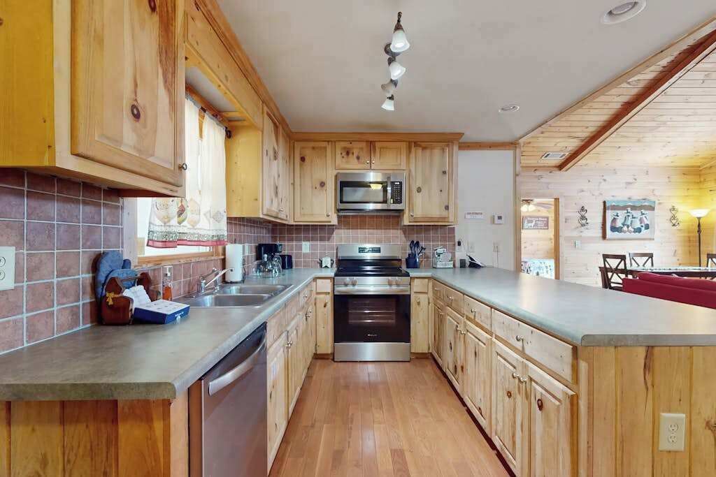 A kitchen with wooden cabinets, a stainless steel oven, and a microwave.