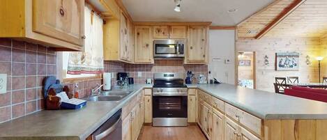 A kitchen with wooden cabinets, a stainless steel oven, and a microwave.