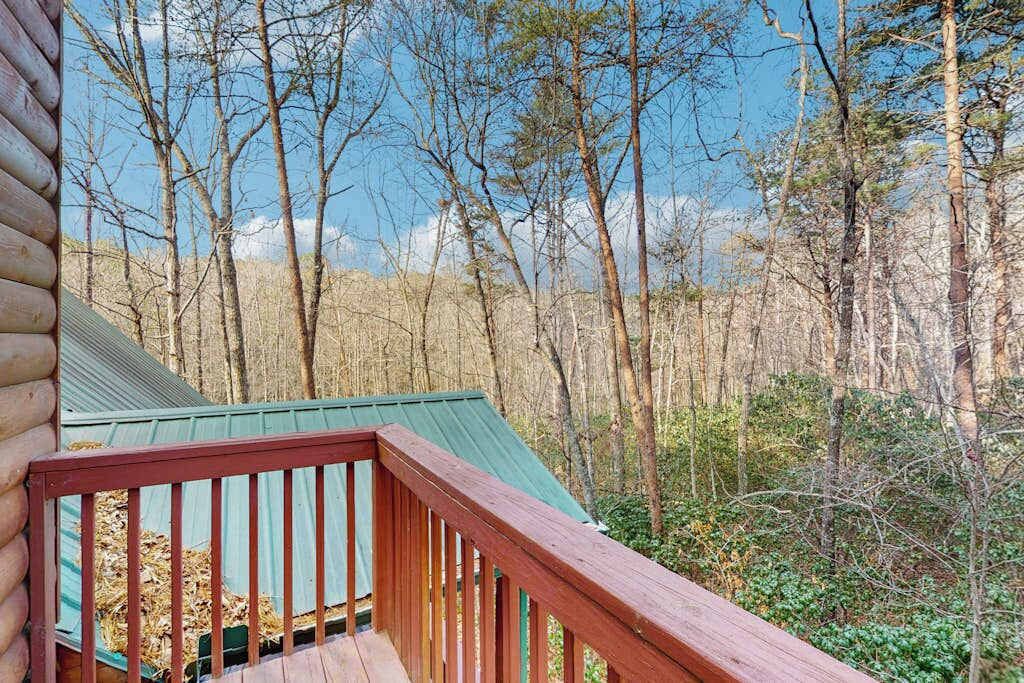 Une cabane avec un toit végétalisé et une terrasse en bois.