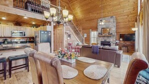 Ein geräumiger Holzblockbau mit Essbereich, Küche und Wohnzimmer.