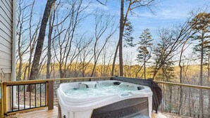A hot tub on a wooden deck with a view of trees. - Maple Summit Ellijay (Ellijay)