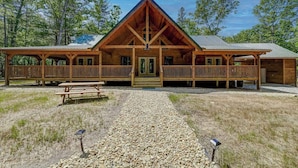A lodge with a central wooden structure, a covered porch, and a gravel pathway. - The Mountain Chapter (Blairsville)