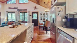 Un'ampia cucina con pavimento in legno, una grande isola e elettrodomestici moderni.