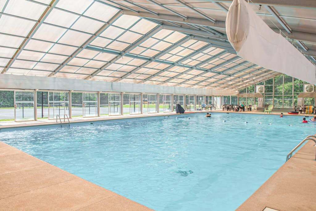 Ein Innenpool mit Glasdach, einem hellen Poolbereich und mehreren Bahnen.