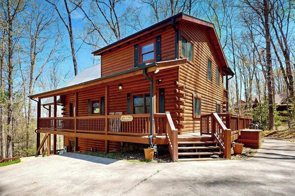 A log cabin with a porch, multiple windows, and a staircase leading to the entrance. - Hid n Timber Getaway (Blue Ridge)