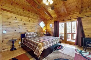 A wooden cabin bedroom with a bed, a small table, and a window. - Hid n Timber Getaway (Blue Ridge)
