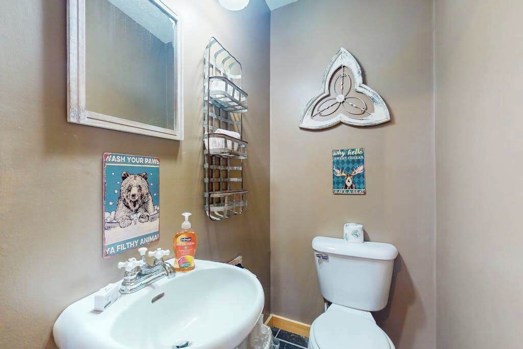 Een badkamer met een wastafel, toilet en spiegel.