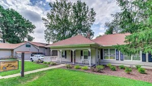 A two-story building with a porch, a sign for 'Upcountry Inn,' and a well-maintained lawn.