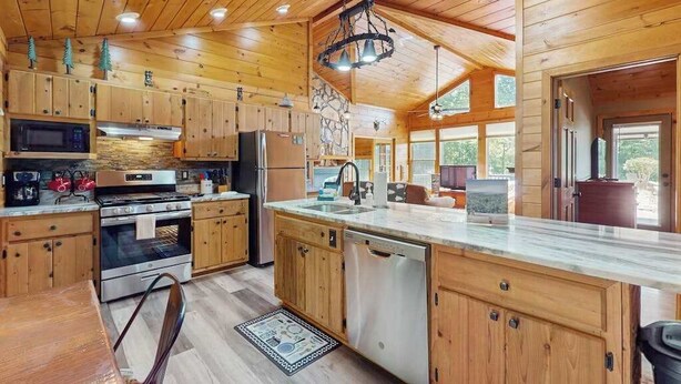 A wooden cabin interior with a kitchen, dining area, and large windows. - Time Out Blue Ridge - Hot tub (Blue Ridge)