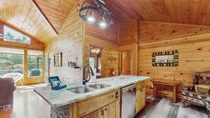 A wooden cabin interior with a kitchen, dining area, and large windows. - Time Out Blue Ridge - Hot tub (Blue Ridge)