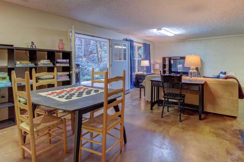 Une pièce comprenant une table à manger, des chaises, un bureau, un ordinateur et une bibliothèque.