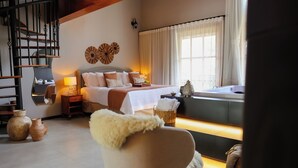 A bedroom with a bed, bedside table, lamp, and a window with curtains.