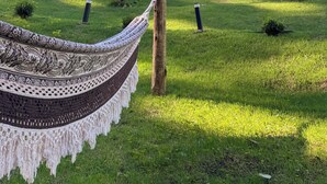 A hammock in a grassy area with a building in the background.