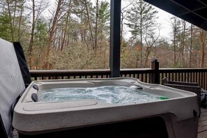 A hot tub on a wooden deck with a forest view. - Sunny Bear Escape Stay (Blue Ridge)