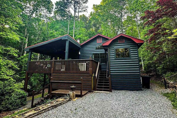 A cabin with a wooden deck, a covered porch, and a staircase leading to the main entrance. - Sunny Bear Escape Stay (Blue Ridge)