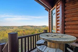 A wooden deck with a round table and benches, overlooking a mountainous landscape. - Majestic Lodge Retreat (Morganton)
